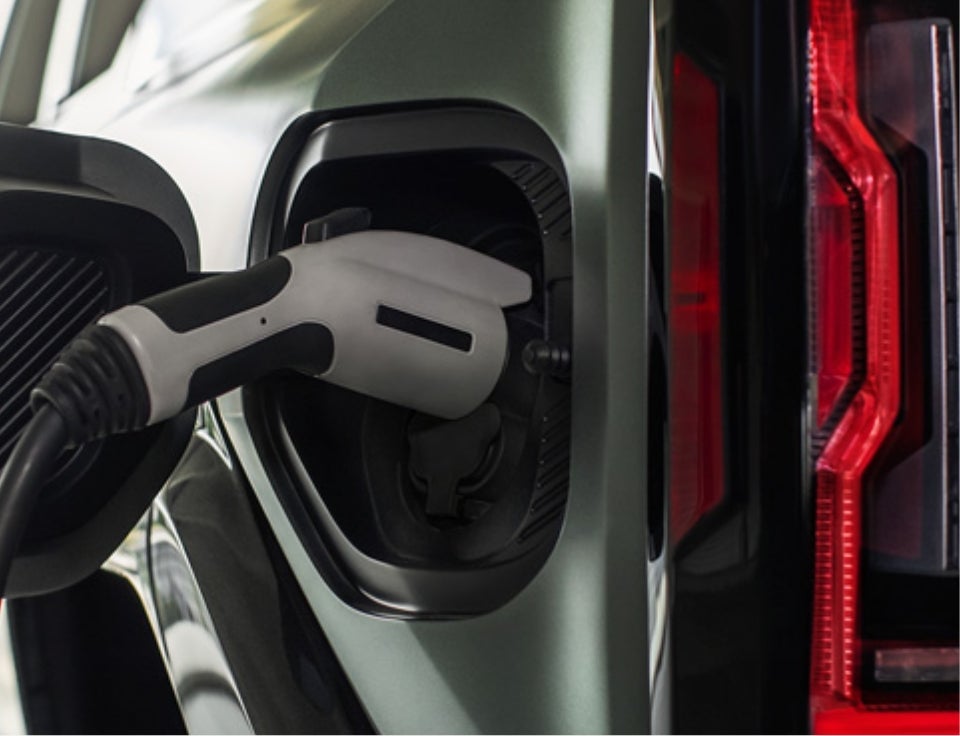 Close up of charging port with charger plugged in on a GMC Hummer EV SUV - Sunrise Buick GMC at Collierville in COLLIERVILLE TN